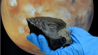 foto di un meteorite con foto di Marte in sottofondo